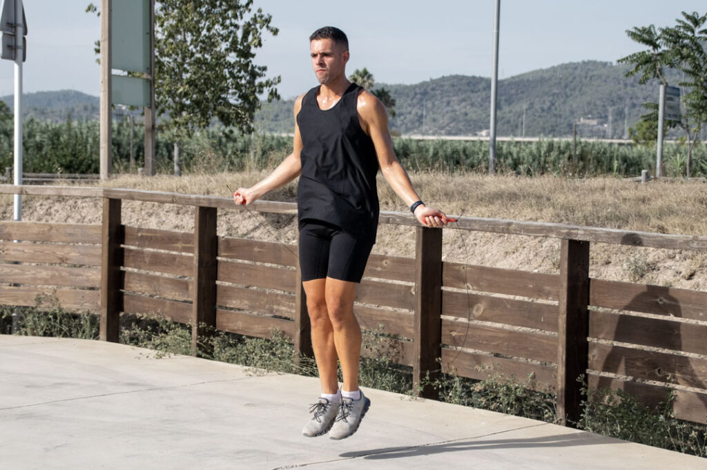 Ejercicios de fuerza para corredores. Runner saltando a la comba para mejorar resistencia y coordinación en carrera.